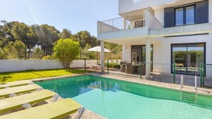 A modern two-story house with a swimming pool, outdoor seating, and a view of trees. - Awesome home in Cala Ratjada (Cala Ratjada)