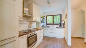 A modern kitchen with white cabinets, a wooden countertop, and a built-in oven. - Stunning home in Canyamel with private swimming pool, can be inside or outside (Canyamel)
