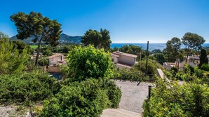 A coastal village with terraced houses, a paved path, and a view of the sea. - Stunning home in Canyamel with private swimming pool, can be inside or outside (Canyamel)