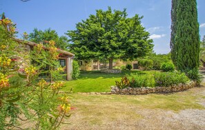 A rustic house with a well-maintained garden, stone walls, and a large tree. - Casa S'Era de Costitx (Costitx)