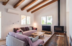 A cozy living room with a sofa, a coffee table, a TV, and a fireplace. - Ses Set Tanques de Son Fosquet (Llucmajor)