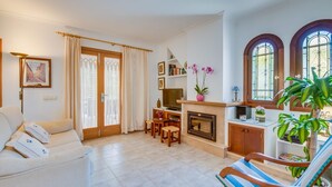 A living room with a sofa, a TV, a fireplace, and a dining area. - Calma de Son Serra de Marina (Son Serra de Marina)