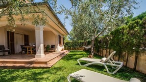 A patio with a table and chairs, a hammock, and a lawn. - Calma de Son Serra de Marina (Son Serra de Marina)