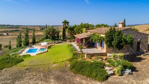 Una villa con piscina, mobiliario exterior y vistas al campo.