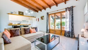 Uma sala de estar com sofá, mesa de centro e vista para o exterior.