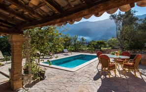 Un espace piscine agrémenté d’une pergola, de coins salon extérieurs et offrant une vue sur les montagnes.