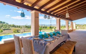 Ein Essbereich im Freien mit Blick auf Pool und Landschaft.