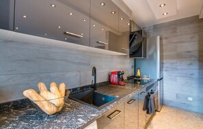 A modern kitchen with a granite countertop, stainless steel appliances, and a built-in oven. - Stunning home in Cala Pi with house sea view (Cala Pi)