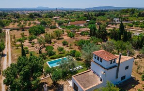 A white building with a red-tiled roof, surrounded by greenery and a clear blue sky. - Beautiful home in Binissalem (Binissalem)