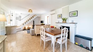 Une cuisine spacieuse avec un coin repas, un escalier et une cheminée.