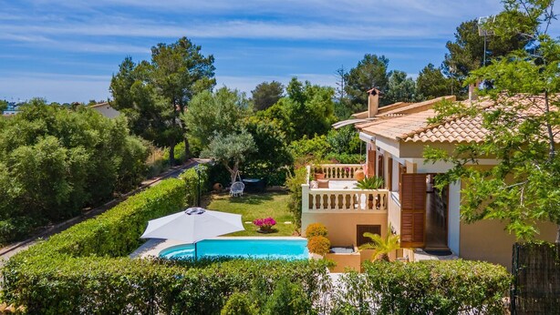 A villa with a swimming pool, surrounded by lush greenery and trees. - Lovely home in Cala Mendia with private swimming pool, can be inside or outside (Cala Mendia)