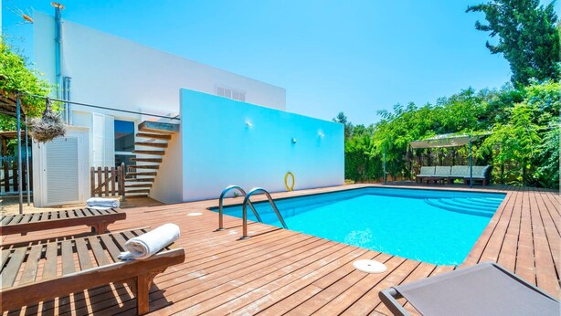 Une piscine extérieure moderne avec une terrasse en bois, des chaises longues et un escalier menant à un niveau supérieur.