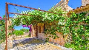 A stone building with a rustic archway covered in flowering vines. - Beautiful home in Es Trenc with private swimming pool, can be inside or outside (Es Trenc)