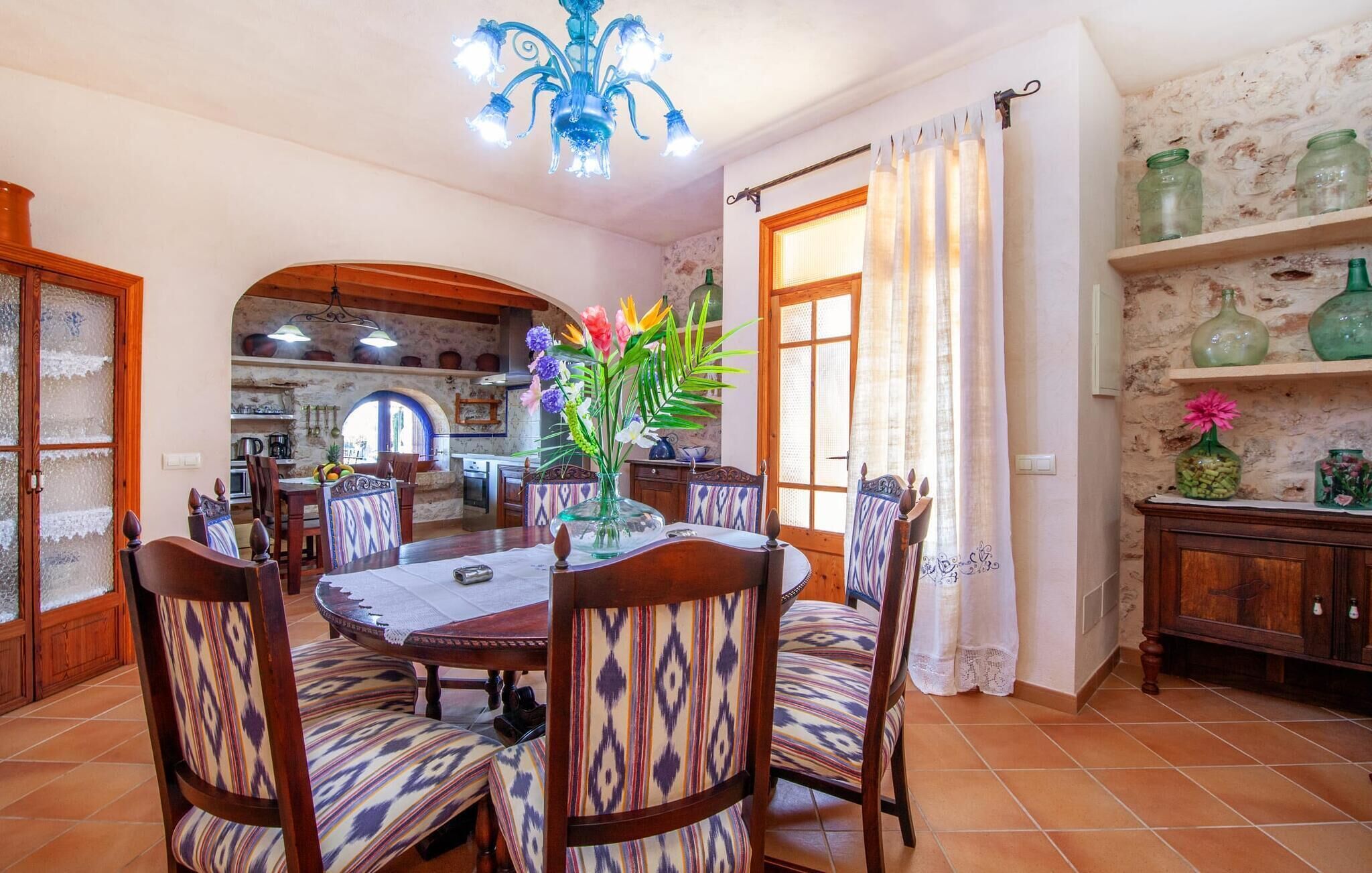 Zona pranzo con tavolo rotondo, sedie e lampadario.
