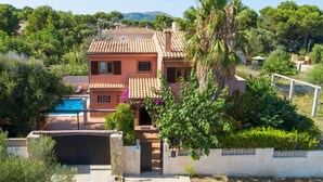 A two-story house with a swimming pool, surrounded by lush greenery and a mountainous backdrop. - Awesome home in Cala Ratjada (Cala Ratjada)