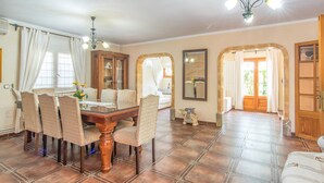 A dining area with a wooden table and chairs, a cabinet, and a mirror. - Awesome home in Cala Ratjada (Cala Ratjada)