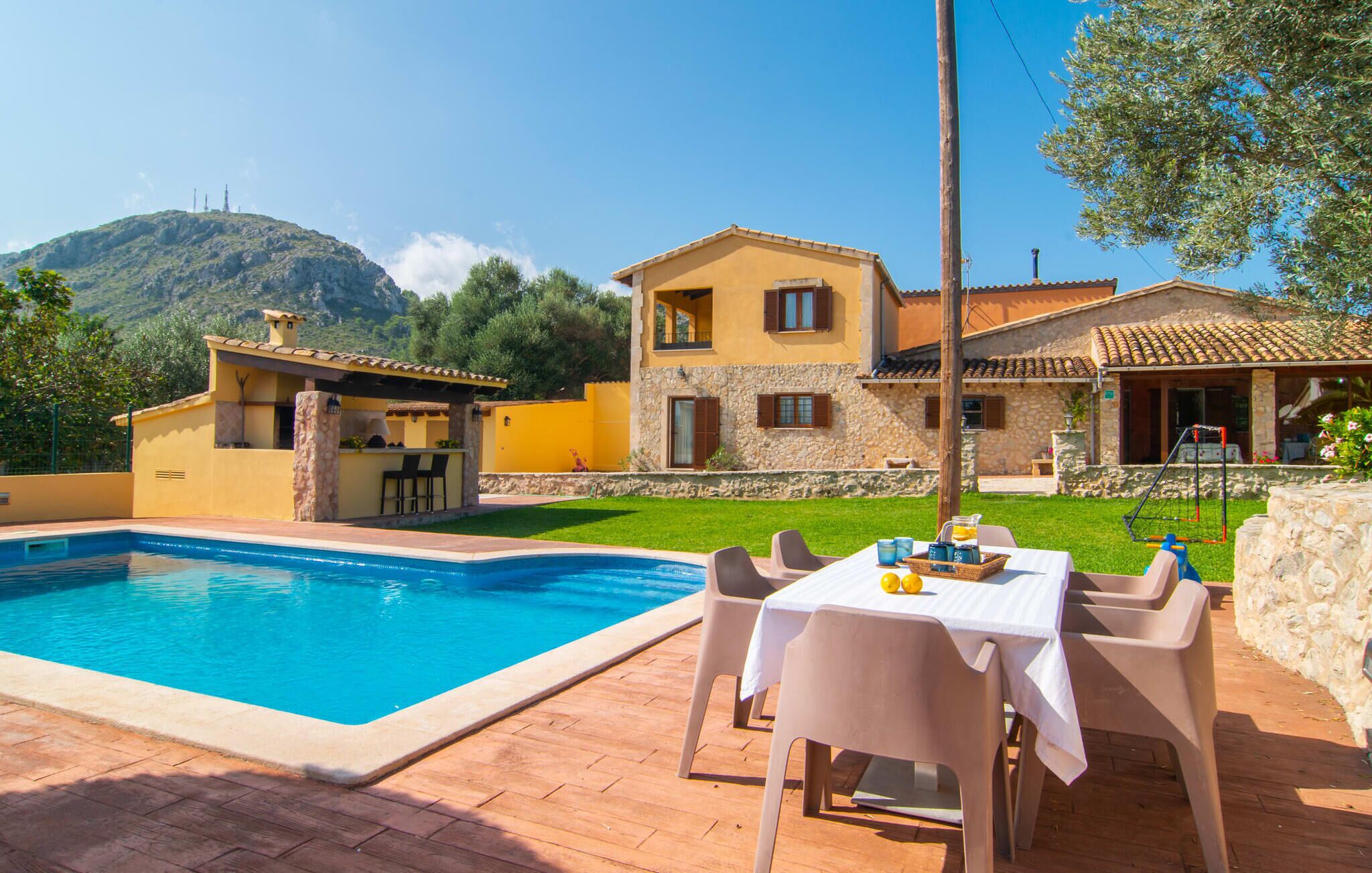 Eine Villa mit Swimmingpool, Außenbereich zum Sitzen und einer Fassade aus Stein.