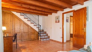 Un vaste espace de vie comprenant un escalier en bois, un canapé et une table à manger.