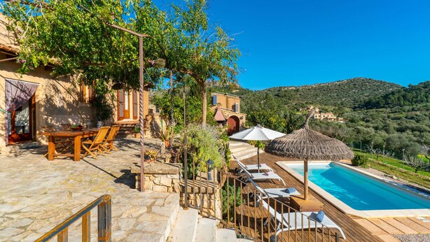 A villa with a stone staircase leading to a wooden deck, a pool, and a view of the surrounding hills. - Cozy home in Son Macia with private swimming pool, can be inside or outside (Son Macia)