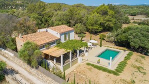 A villa with a swimming pool, surrounded by trees and hills. - Gorgeous home in Canyamel with private swimming pool, can be inside or outside (Canyamel)