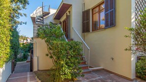 A narrow, tiled courtyard with a staircase leading to a second floor. - Beach front home in Canyamel (Canyamel)