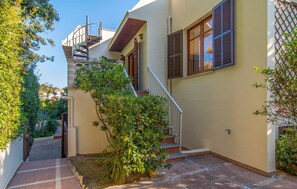 A narrow, tiled courtyard with a staircase leading to a second floor. - Beach front home in Canyamel (Canyamel)