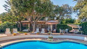 A pool area with a hot tub, lounge chairs, and a dining area with outdoor furniture. - Beach front home in Canyamel (Canyamel)