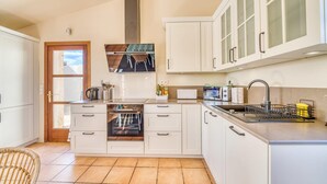 A compact kitchen with white cabinets, a built-in oven, a microwave, and a sink. - Es Pasarell de Felanitx (Felanitx)