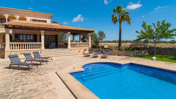 A poolside area with lounge chairs and a swimming pool. - Lovely home in Cala Santanyi (Cala Santanyi)