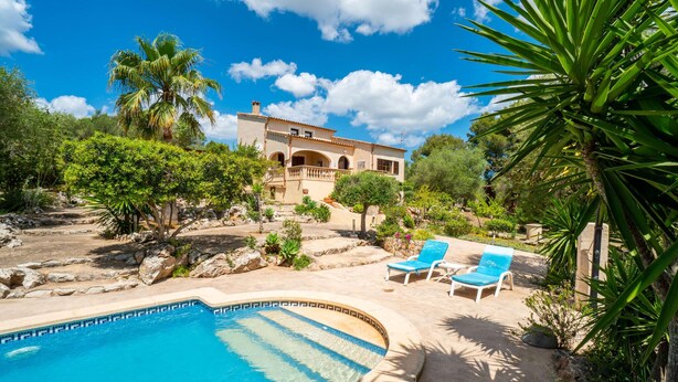 A pool area with two blue lounge chairs, a stone pathway, and a building with arches in the background. - Beautiful home in Arta with private swimming pool, can be inside or outside (Arta)