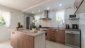 Una cocina moderna con una isla central, electrodomésticos de acero inoxidable y lavavajillas.