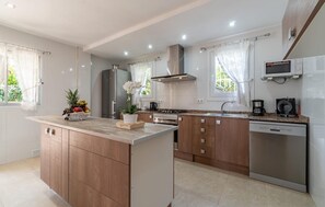 A modern kitchen with a central island, stainless steel appliances, and a dishwasher. - Awesome home in Alcudia with WiFi (Alcudia)