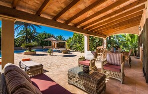 A covered outdoor area with wicker furniture, a pool, and tropical plants. - Stunning home in Cala dOr with private swimming pool, can be inside or outside (Cala dOr)