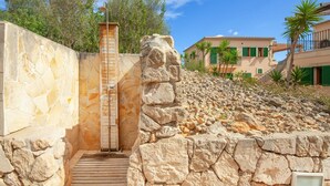 A stone staircase leading to a wooden door, surrounded by a stone wall and a rocky hillside. - Beautiful home in Felanitx with sauna (Felanitx)