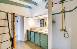 Ein Badezimmer mit Waschbecken, Spiegel und Dusche.