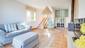 A spacious living room with a sofa, ottoman, and a hanging light fixture. - Awesome home in Son Serra de Marina with WiFi (Son Serra de Marina)