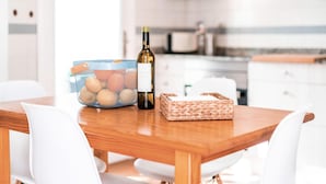 A wooden table with a bottle of wine, a basket, and a mesh container with eggs. - Awesome home in Son Serra de Marina with WiFi (Son Serra de Marina)