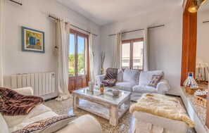 A living room with a white sofa, a coffee table, and a radiator. - Buena Vista de Cala Pi (Cala Pi)