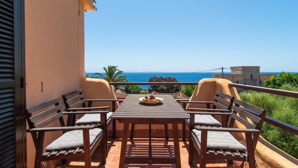 A balcony with a table and four chairs, overlooking a coastal view. - Buena Vista de Cala Pi (Cala Pi)