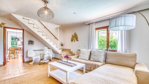 Una sala de estar moderna con una escalera, un sofá, una mesa de centro y un comedor.