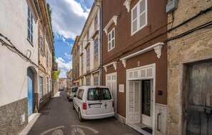 A narrow street lined with historic buildings, a white van parked on the side, and a clear blue sky. - Cozy home in Arta with private swimming pool, can be inside or outside (Arta)