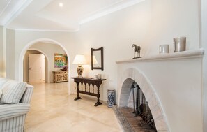 A spacious living room with a fireplace, a sofa, a table with a lamp, and a decorative mirror. - Lovely home in Cala Pi with private swimming pool, can be inside or outside (Cala Pi)