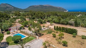 A residential area with a swimming pool, surrounded by trees and a view of the sea and mountains. - Amazing home in Cala Ratjada (Cala Ratjada)