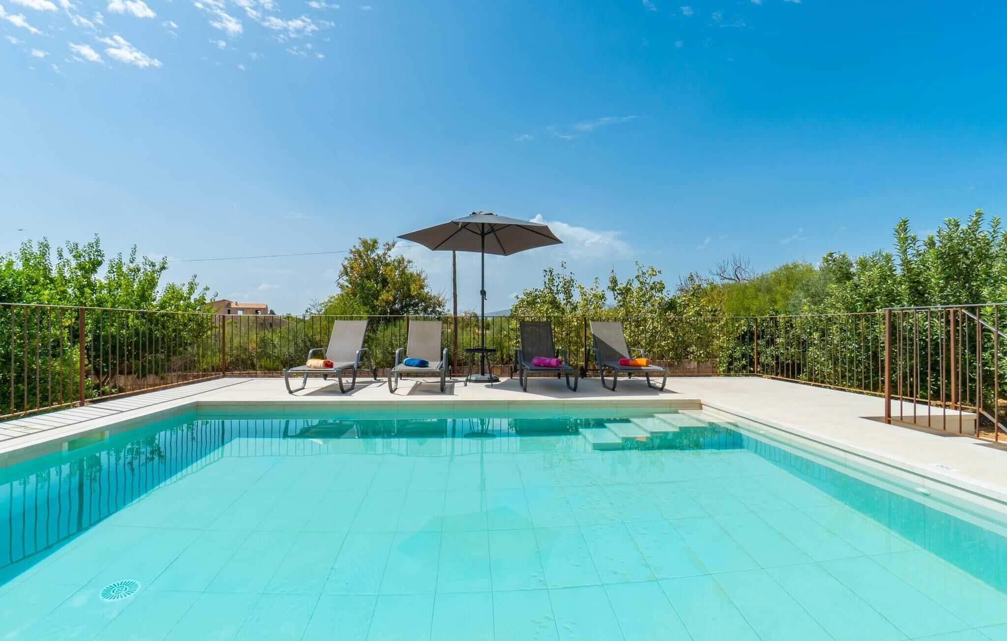 Una piscina amb gandules i una ombrell.