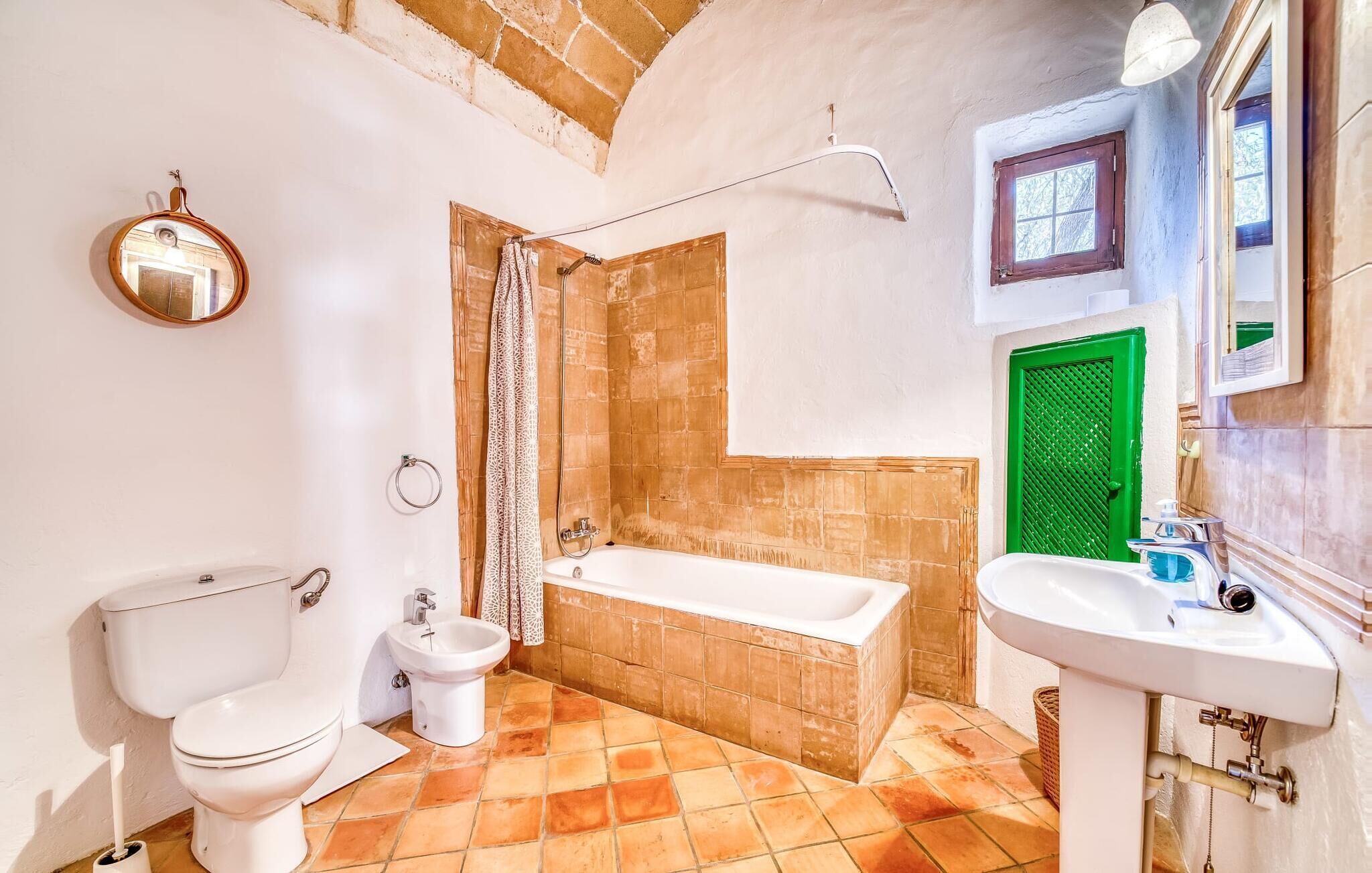 Een badkamer met toilet, bidet, bad en wastafel.