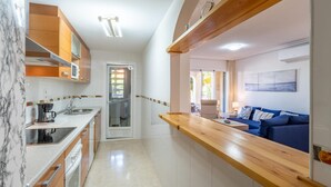 Una cocina moderna con salpicadero de mármol, armarios de madera y horno empotrado.