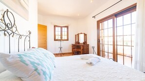 A bedroom with a bed, a dresser, a mirror, and a window. - Stunning home in Son Serra de Marina with house sea view (Son Serra de Marina)