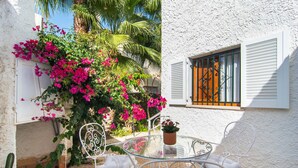 A white building with a window featuring black wrought iron bars. - 3 bedroom gorgeous home in Alcudia (Alcudia)