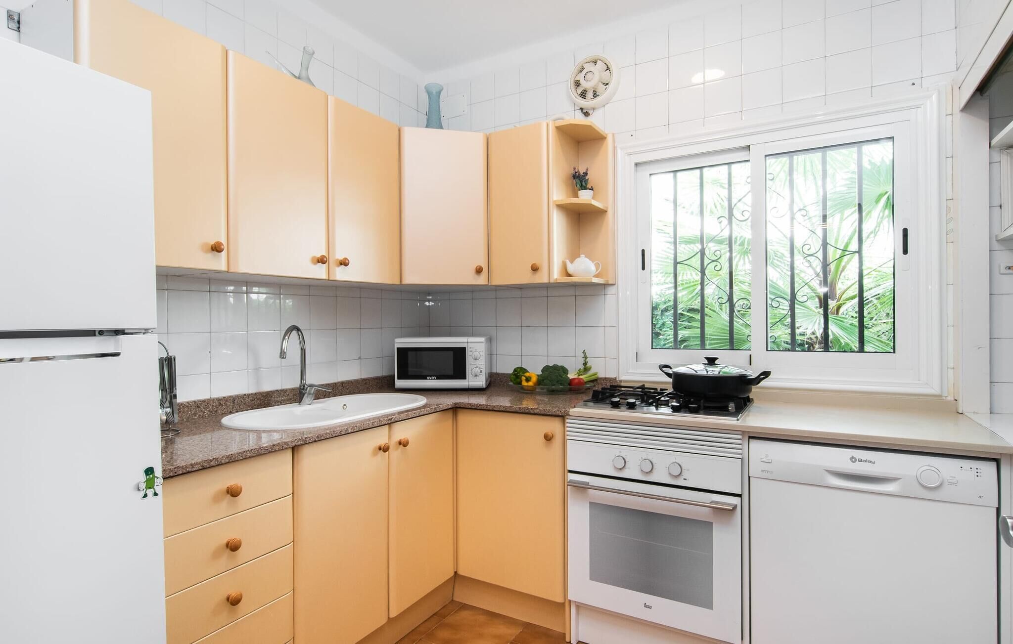 A kitchen with white cabinets, a microwave, a stove, and a dishwasher.