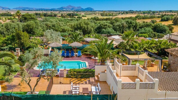 Een resort met een zwembad, terras en uitzicht op de bergen.